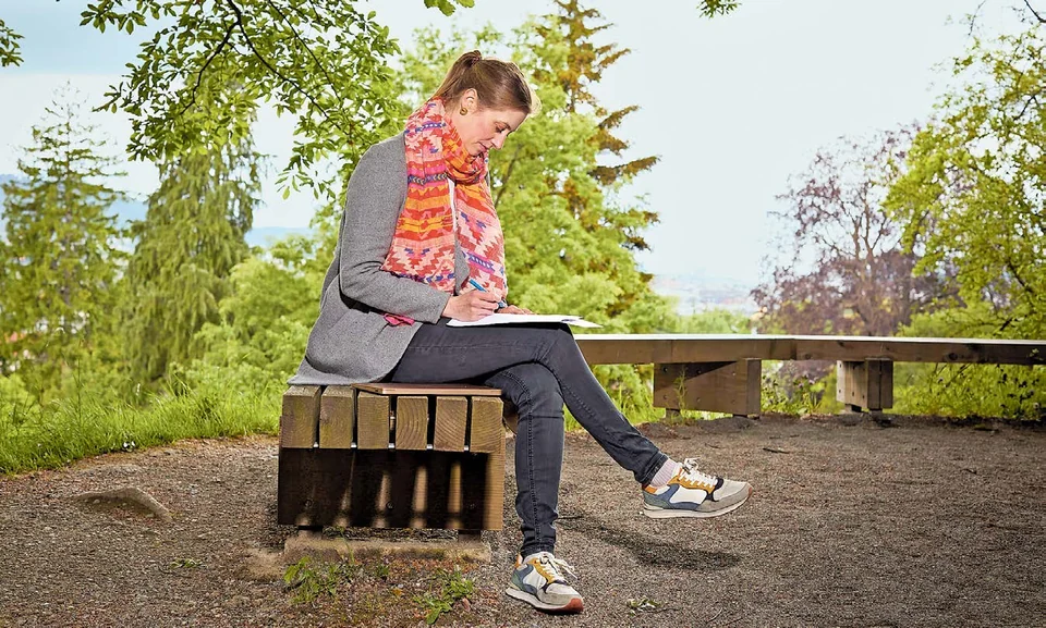 Andrea Horka sitzt mit einem Notizbuch im Botanischen Garten Zürich und sammelt Namensideen.